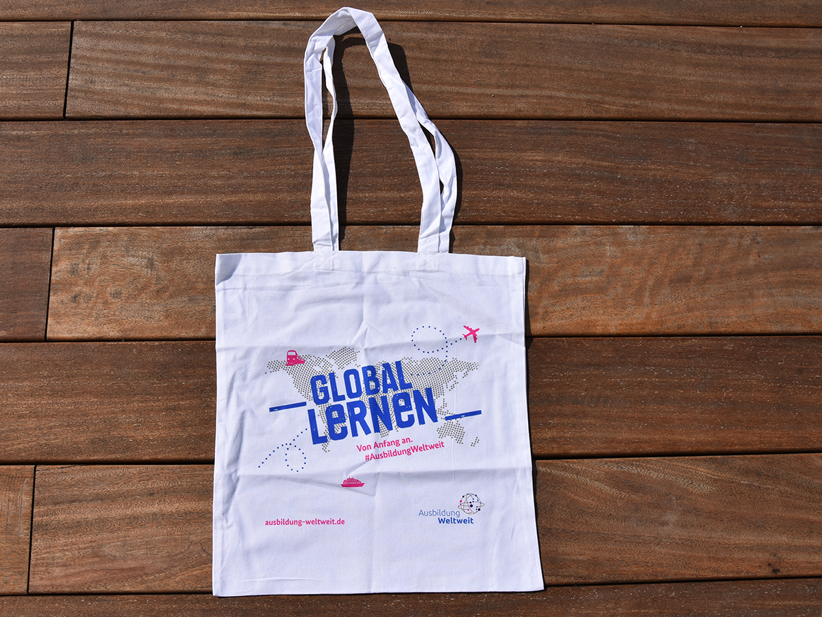 Baumwolltasche mit Weltkarte aus Punkten und Schriftzug "Global lernen von Anfang an".